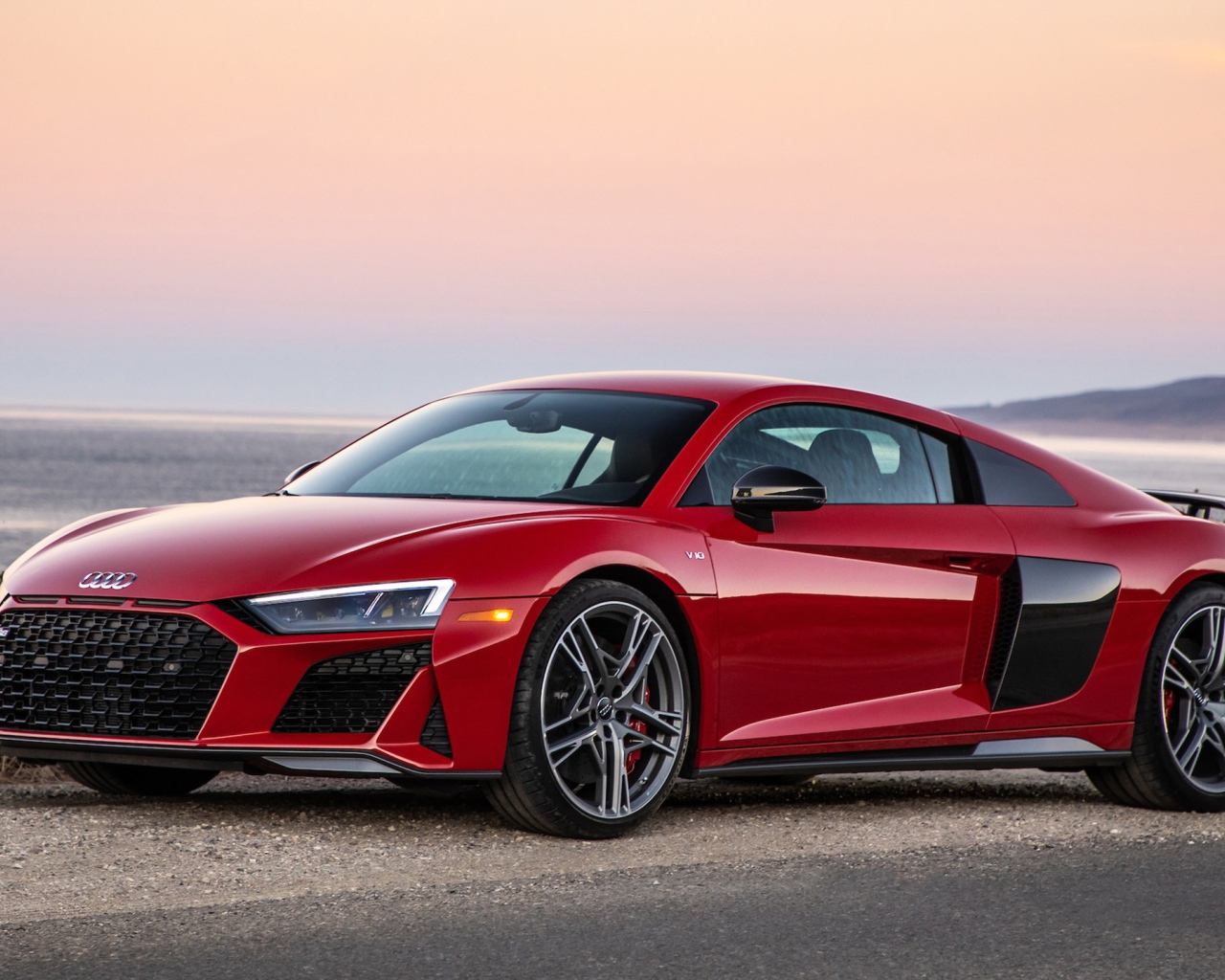 Красный спортивный автомобиль Audi R8 V10, 2020 года на фоне океана