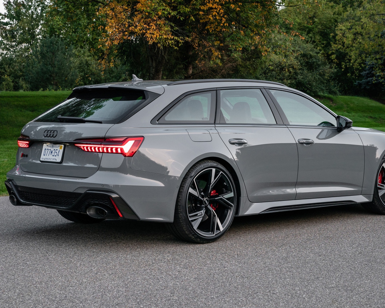 Серебристый автомобиль Audi RS 6 Avant, 2021 года вид сзади