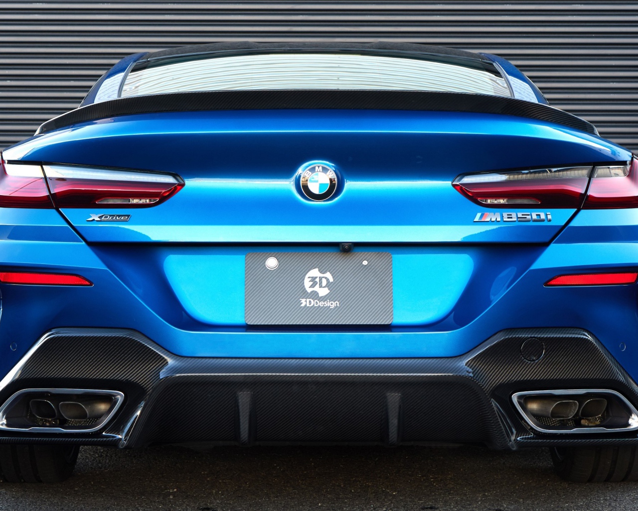 Синий автомобиль BMW M850i XDrive Coupe 2020 года вид сзади