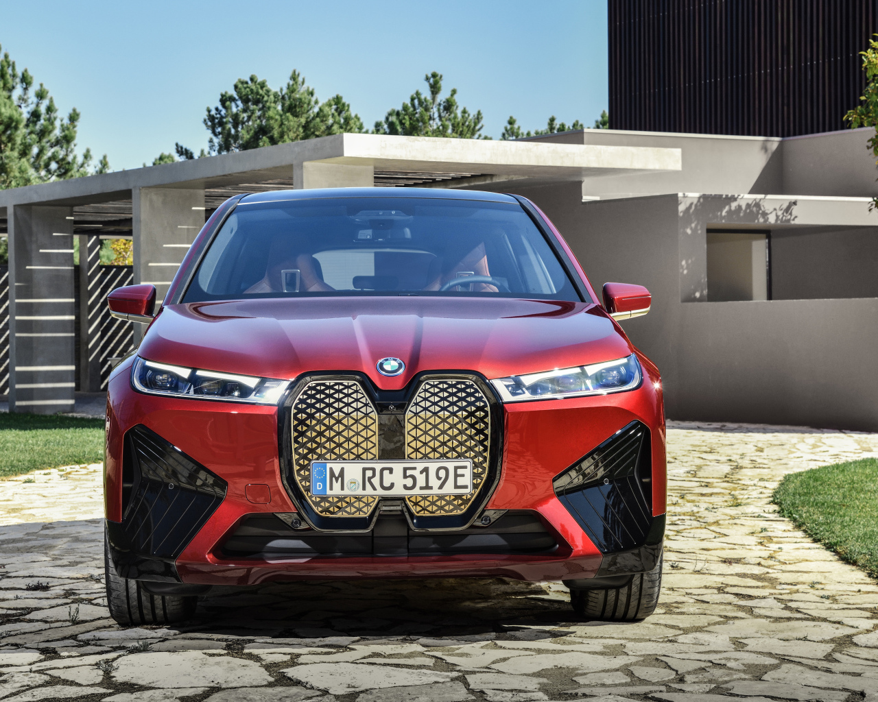 Красный автомобиль BMW IX 2021 года у дома