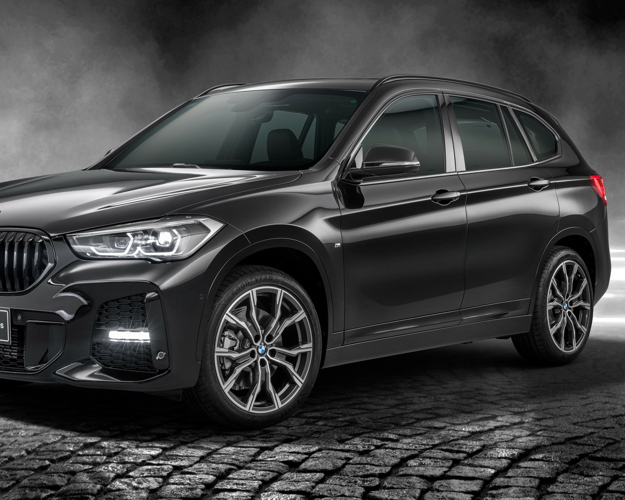 Черный автомобиль BMW X1 SDrive20i M Sport 25 Anos 2020 года в свете софитов