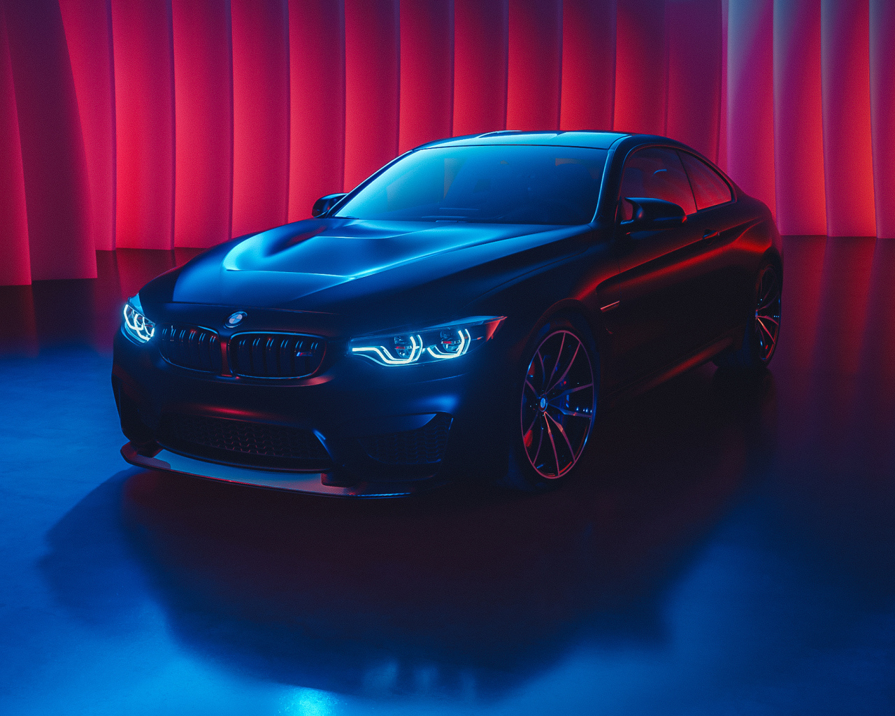 Черный автомобиль BMW M4 с включенными фарами
