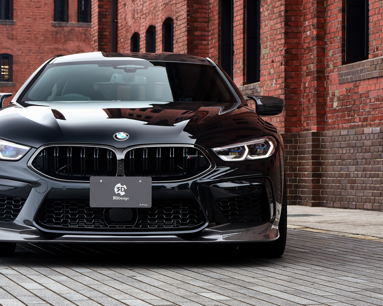 Черный автомобиль BMW M8, 2020 года у кирпичной цены