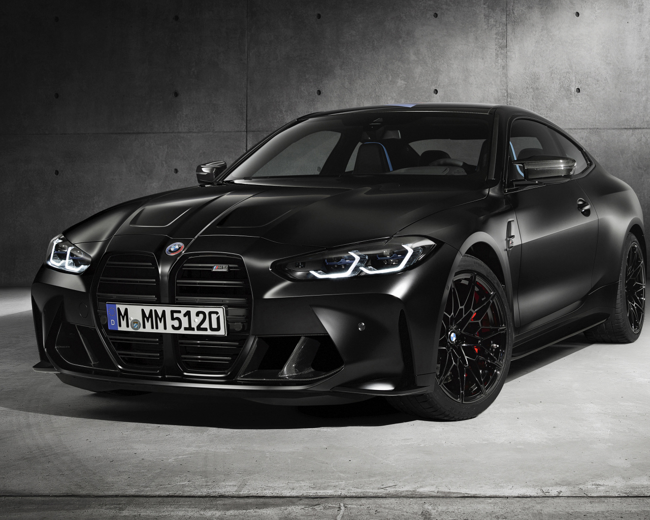 Черный автомобиль BMW M4, 2020 года на сером фоне