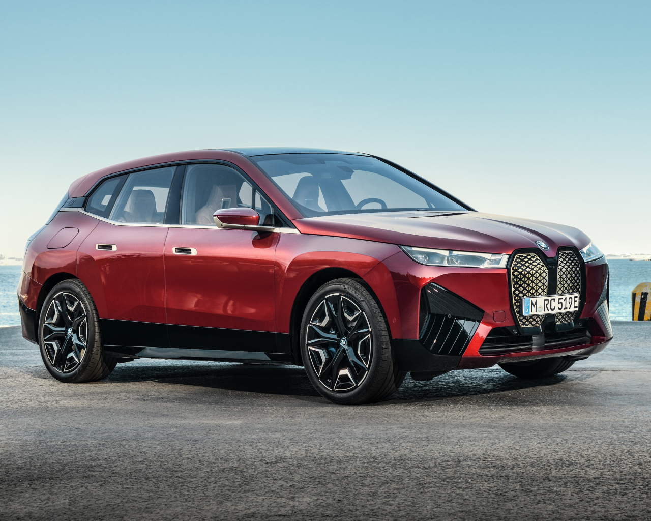 Бордовый автомобиль BMW IX 2021 года у воды