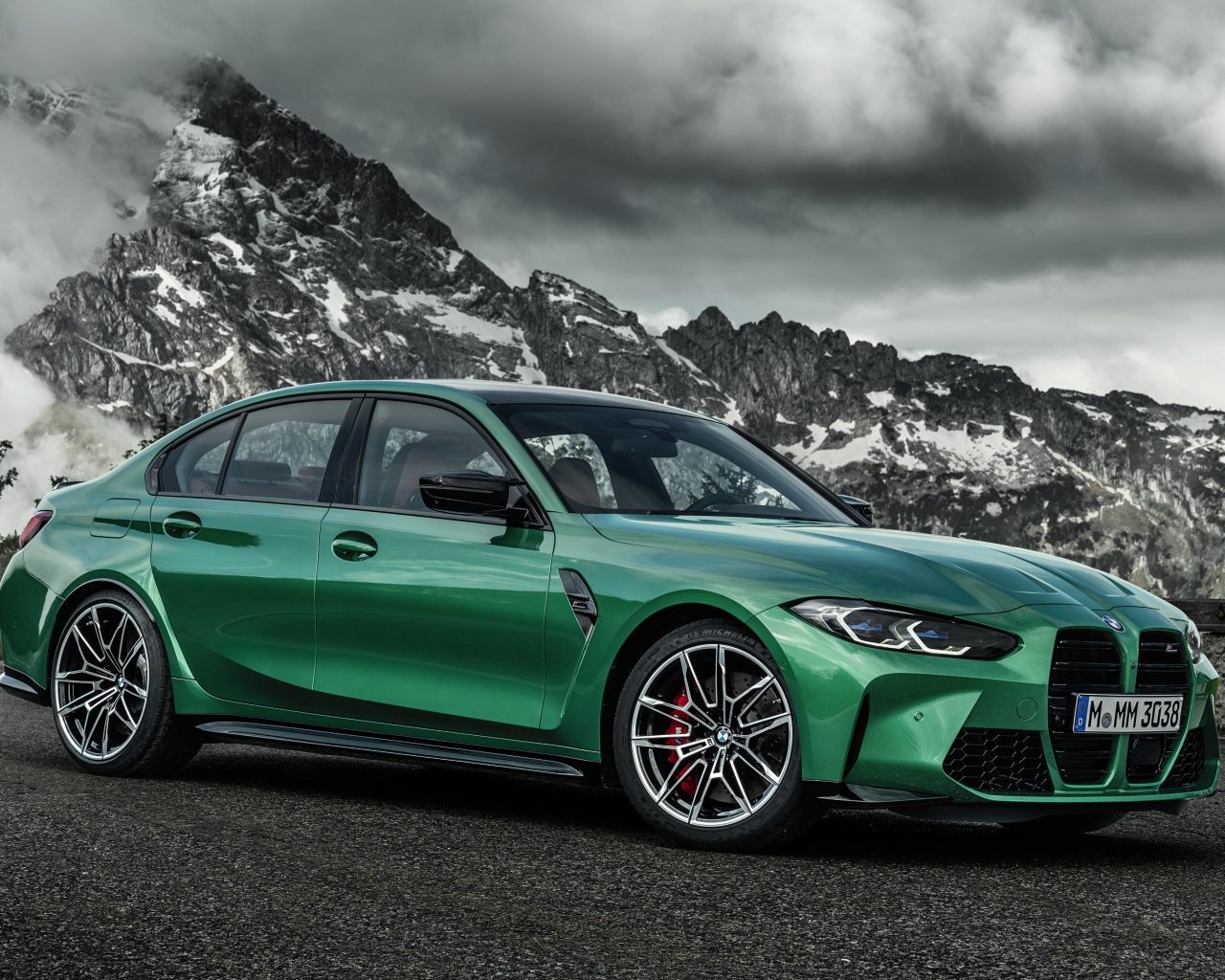Зеленый автомобиль BMW M3 Competition 2020 года на фоне горы
