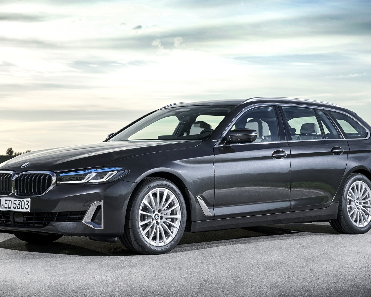 Серебристый автомобиль BMW 530d XDrive 2020 года на дороге 