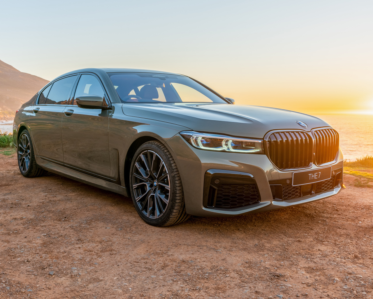 Стильный дорогой автомобиль BMW 745Le , 2020 года на фоне заката