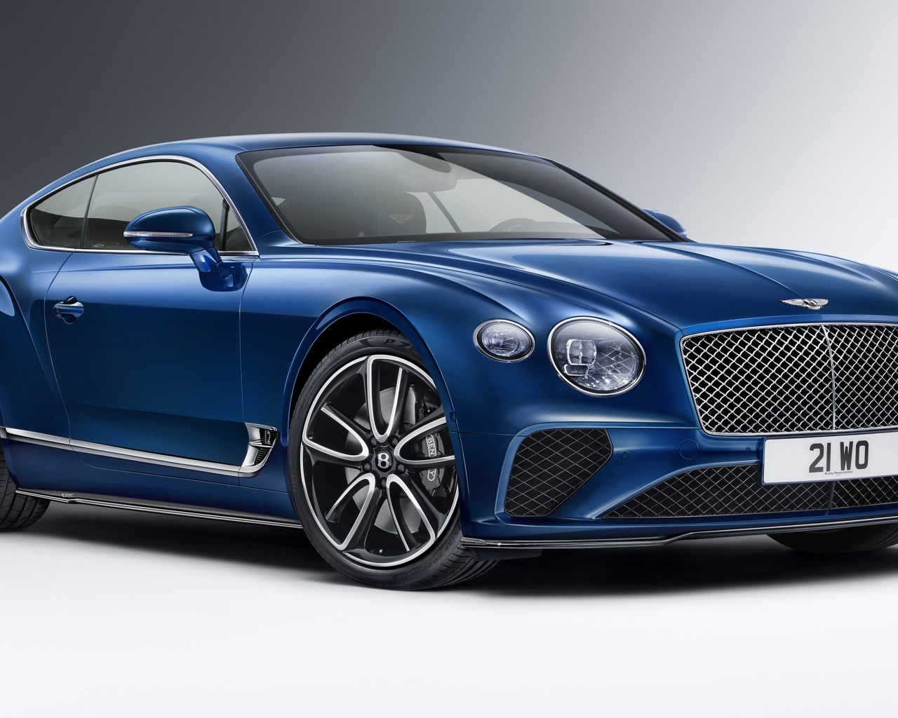 Синий автомобиль Bentley Continental GT Styling 2020 года на сером фоне вид спереди