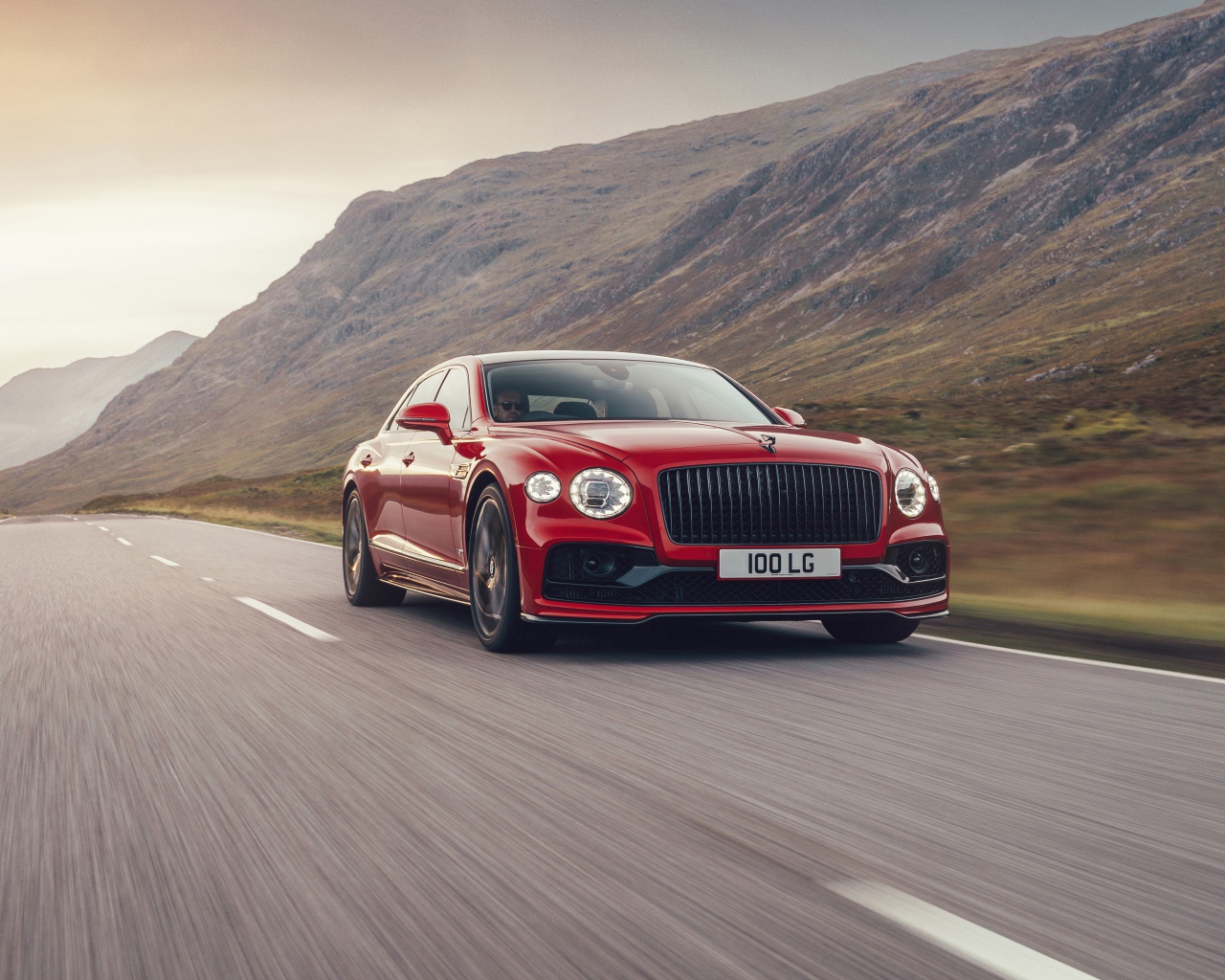 Красный автомобиль Bentley Flying Spur V8 2020 года на дороге  