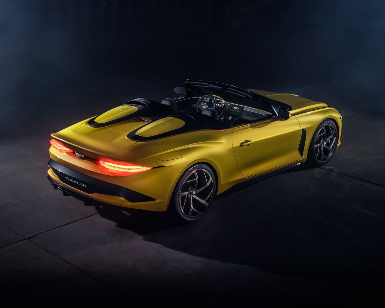 Желтый автомобиль Bentley Mulliner Bacalar 2020 года вид сзади на сером фоне