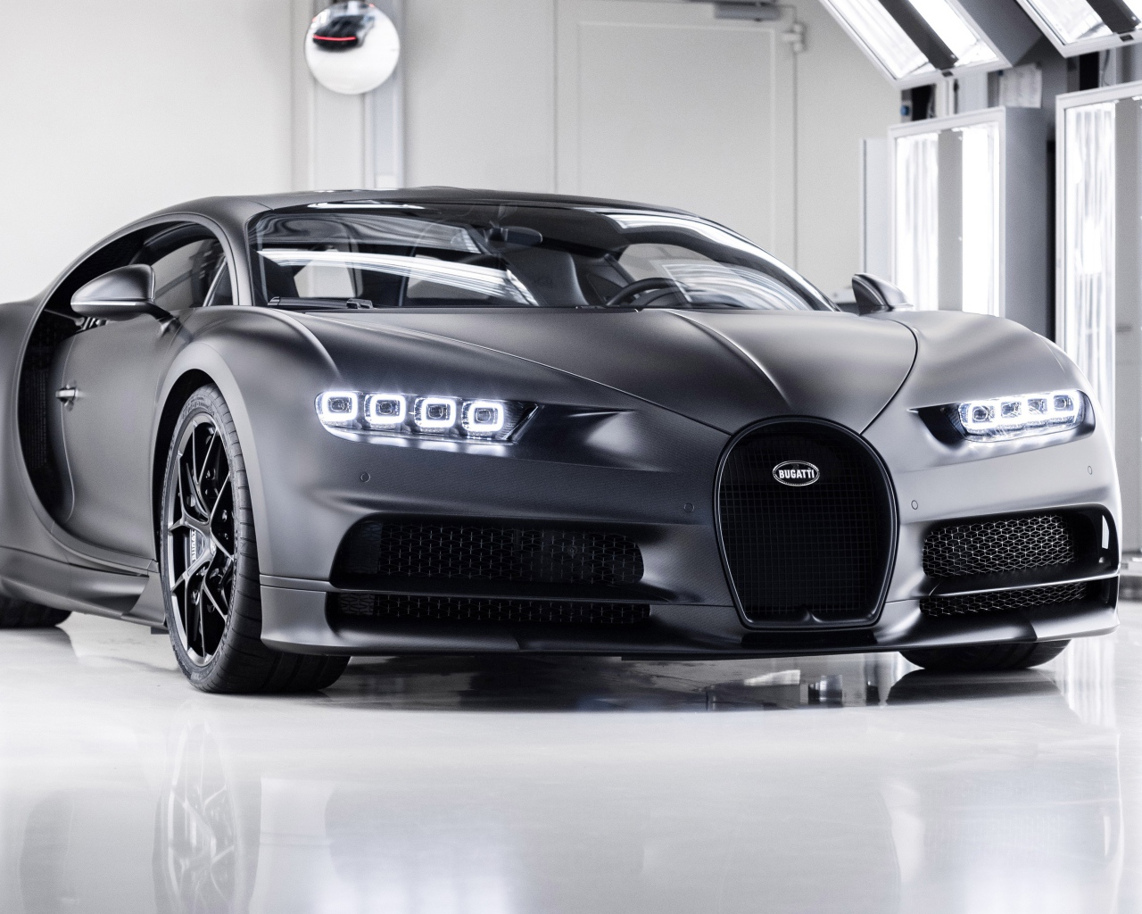 Автомобиль bugatti chiron 2020 года с включенными фарами