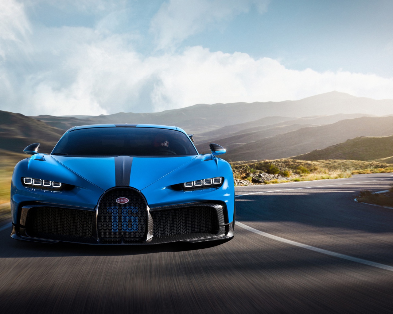 Синий автомобиль Bugatti Chiron Pur Sport 2020 года на трассе в горах 