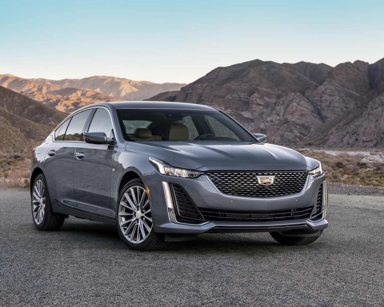 Серебристый автомобиль Cadillac CT5 Premium, 2020 года на фоне гор 