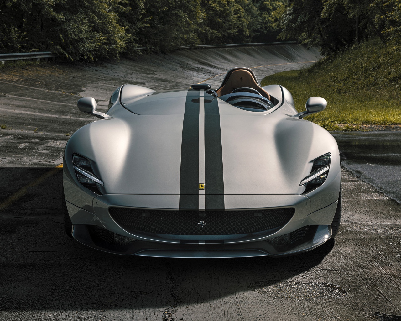 Серебристый кабриолет  Ferrari Monza SP1 2020 года на мокрой трассе 