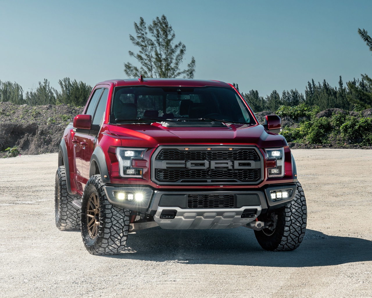 Красный внедорожник Ford F-150 Raptor на песке