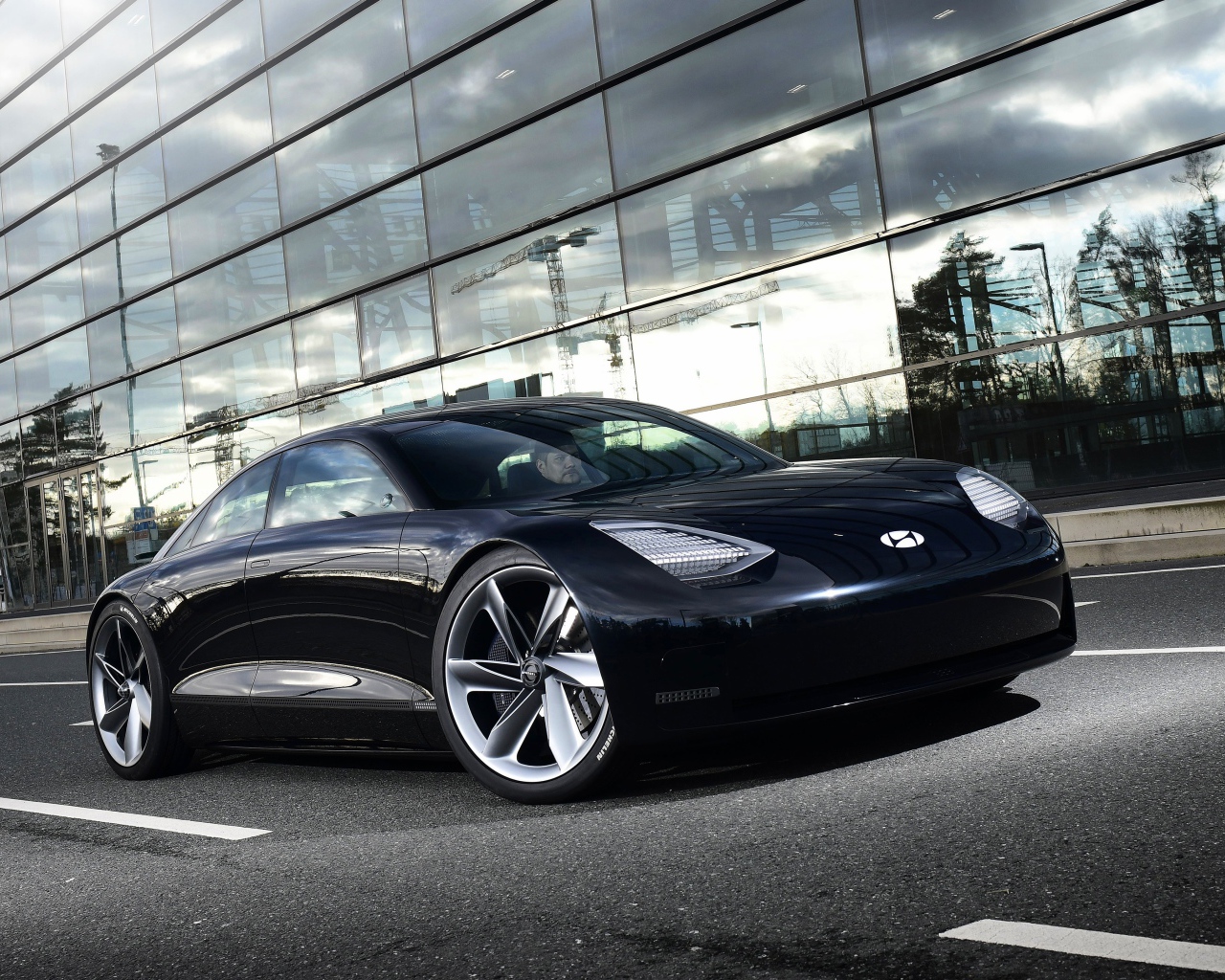 Черный автомобиль Hyundai Prophecy 2020 года у стеклянного здания 