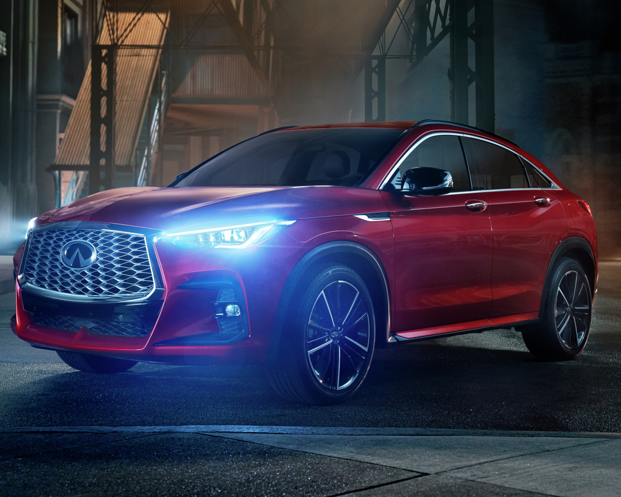 Красный автомобиль Infiniti QX55 AWD, 2022 года с включенными фарами