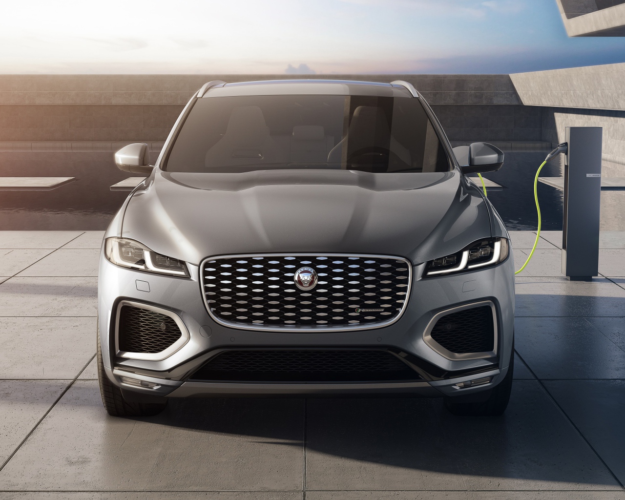 Серый автомобиль Jaguar F-Pace P400e AWD 2020 года на заправке
