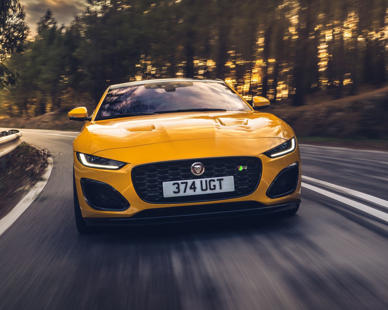 Желтый автомобиль Jaguar F-Type R Coupe 2020 года на трассе 