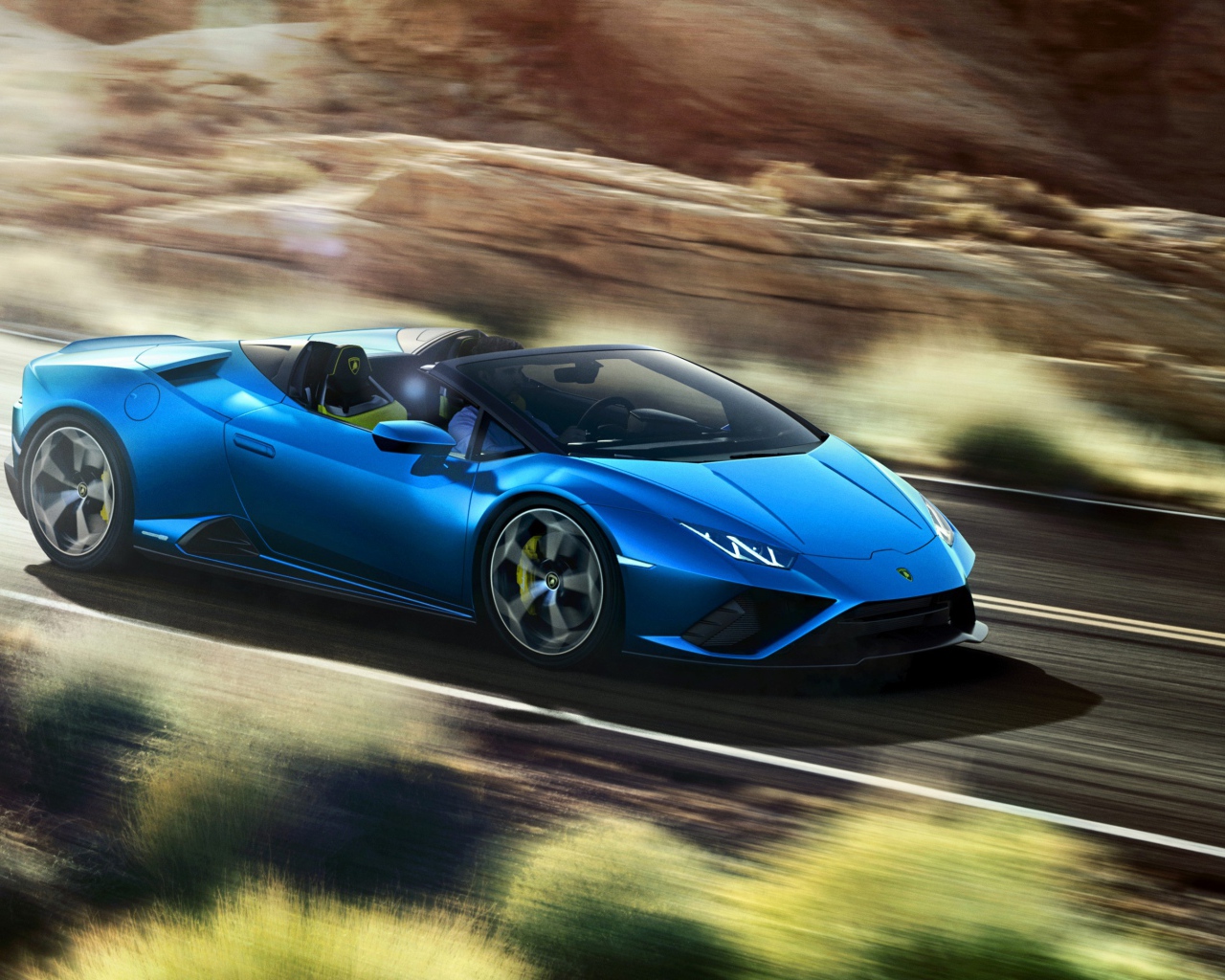 Синий автомобиль Lamborghini Huracan EVO RWD Spyder 2020 года на скорости 