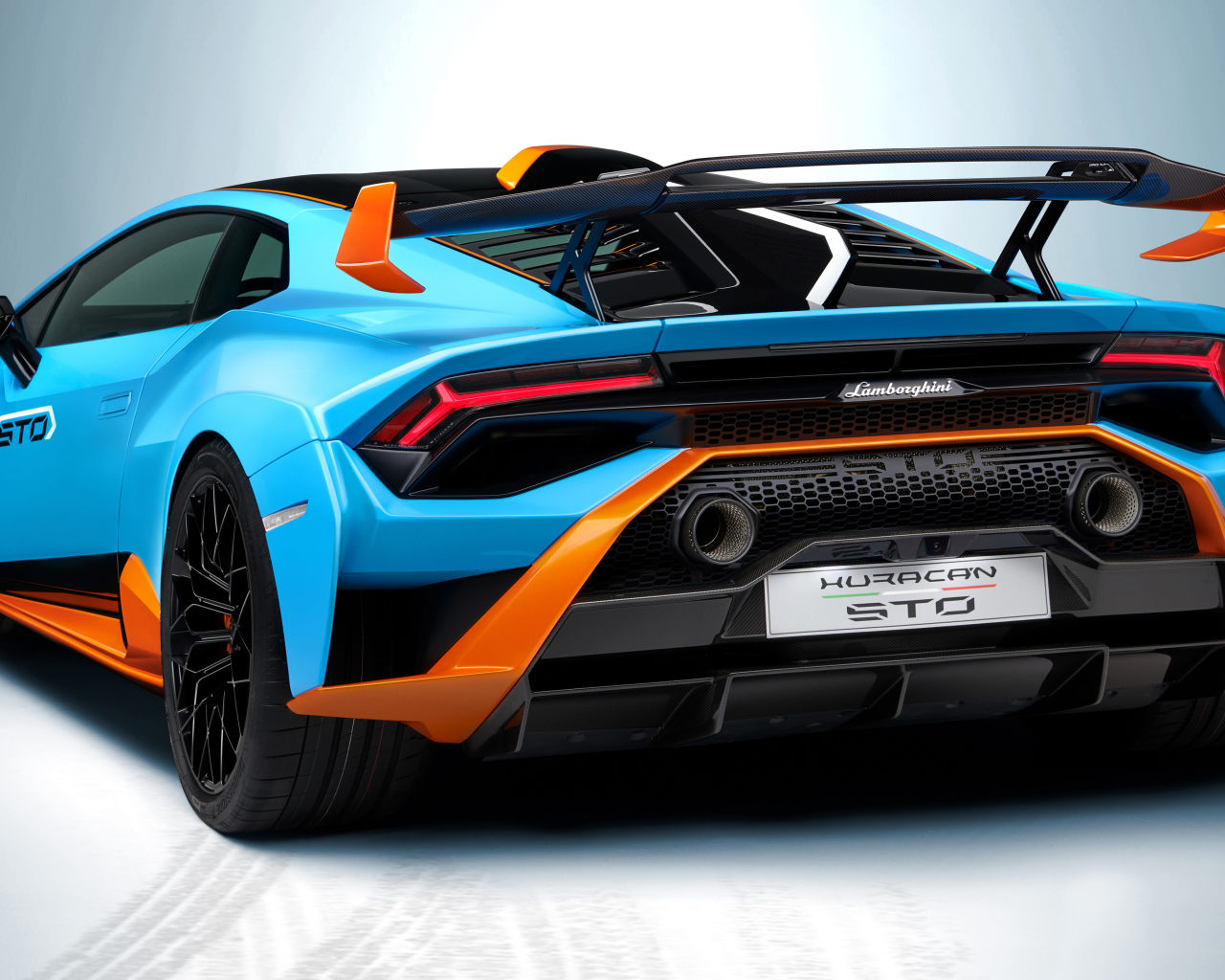 Автомобиль Lamborghini Huracán STO 2021 года вид сзади на сером фоне
