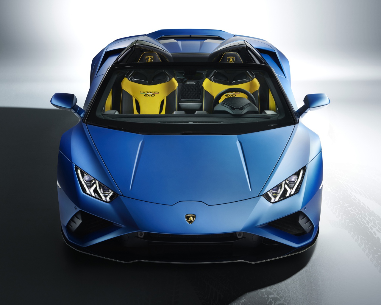 Синий автомобиль Lamborghini Huracan EVO RWD Spyder 2020 года на сером фоне 