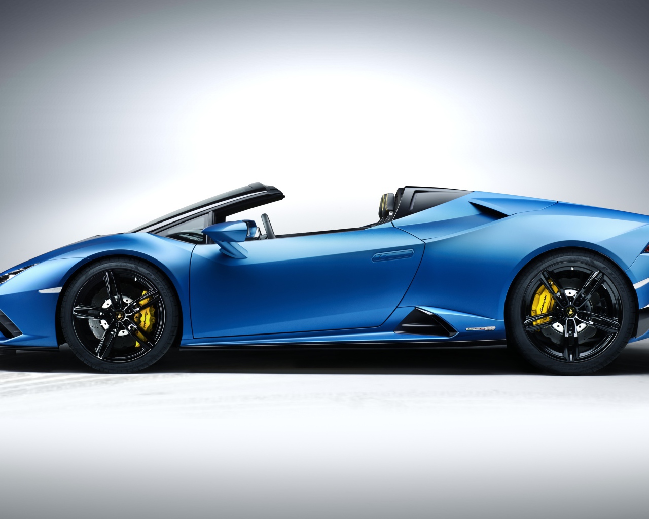 Дорогой быстрый автомобиль Lamborghini Huracan EVO RWD Spyder 2020 года на сером фоне 