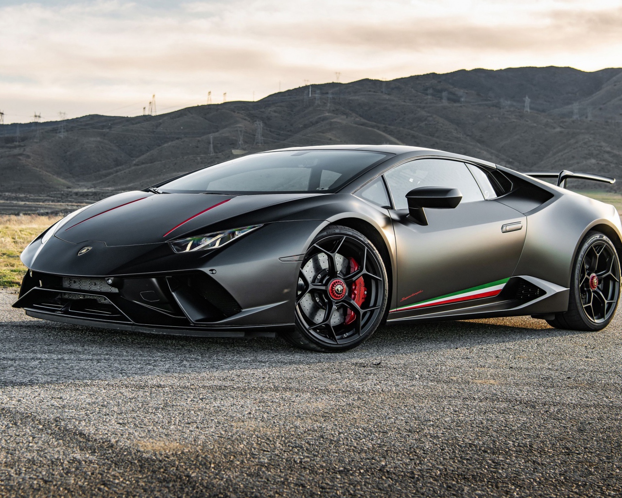 Серебристый спортивный автомобиль  Lamborghini Huracan Performante 2020 года на фоне гор 