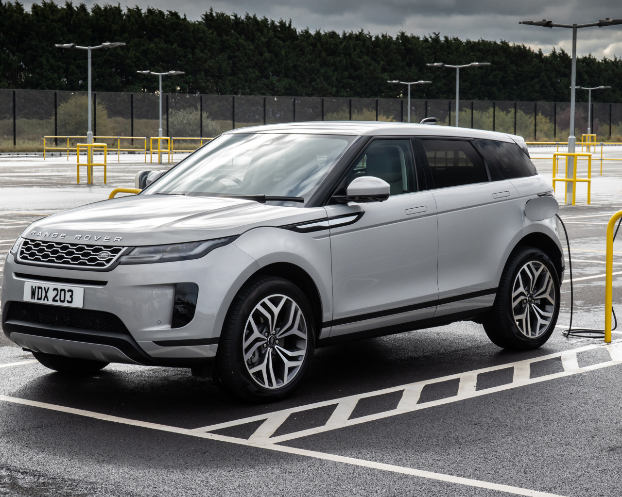 Серебристый автомобиль Range Rover Evoque P300e S 2020 года на заправке