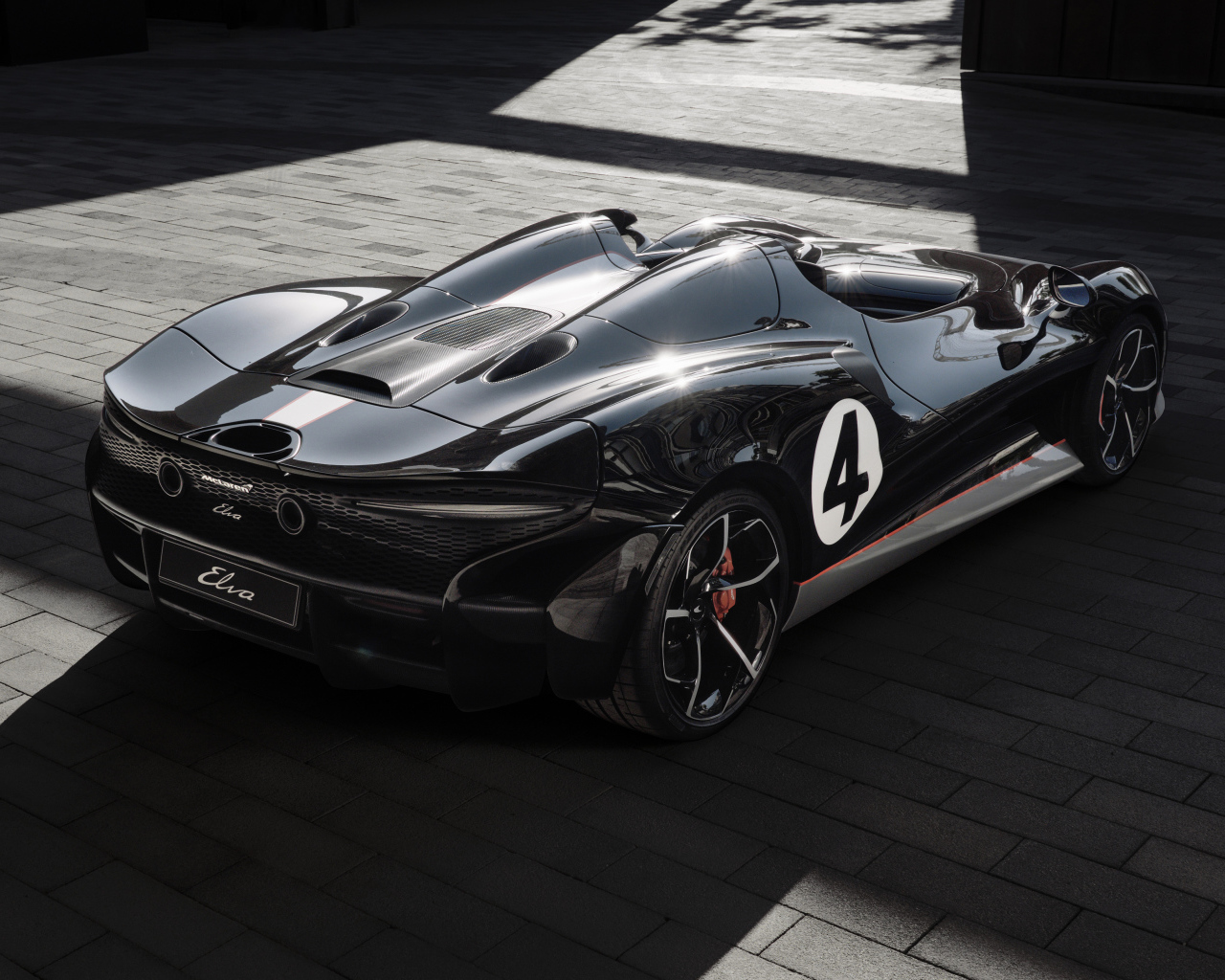 Черный спортивный автомобиль McLaren MSO Elva M1A Theme 2020 года вид сзади