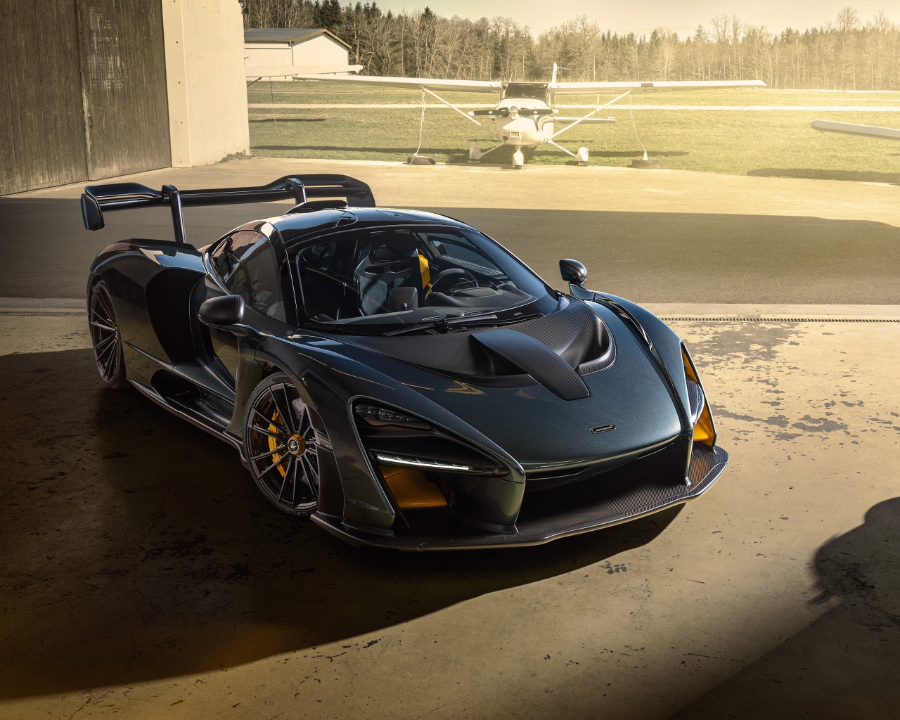 Черный автомобиль  McLaren Senna 2020 года на аэродроме 