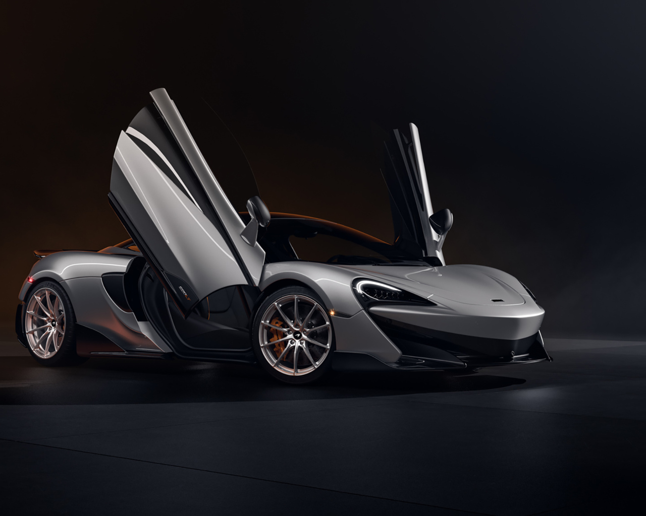 Серебристый спортивный автомобиль McLaren 600LT CGI с открытыми дверями