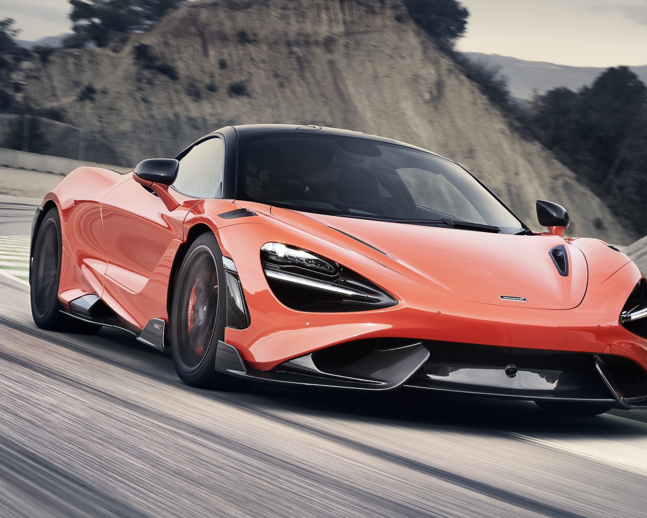 Красный автомобиль McLaren 765LT 2020 года на дороге в горах 