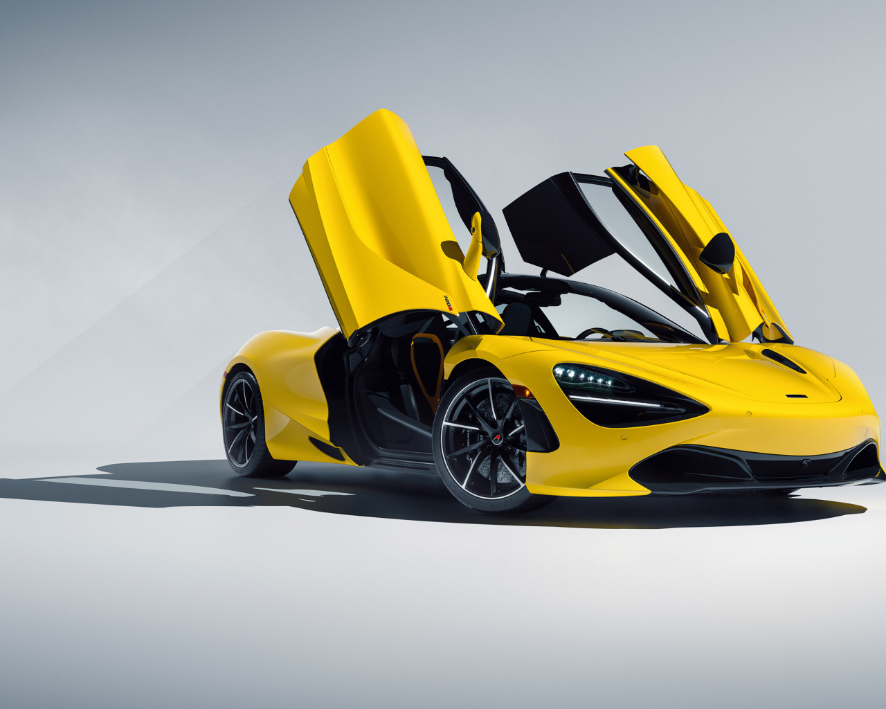 Желтый автомобиль McLaren 720S CGI с открытыми дверями на сером фоне