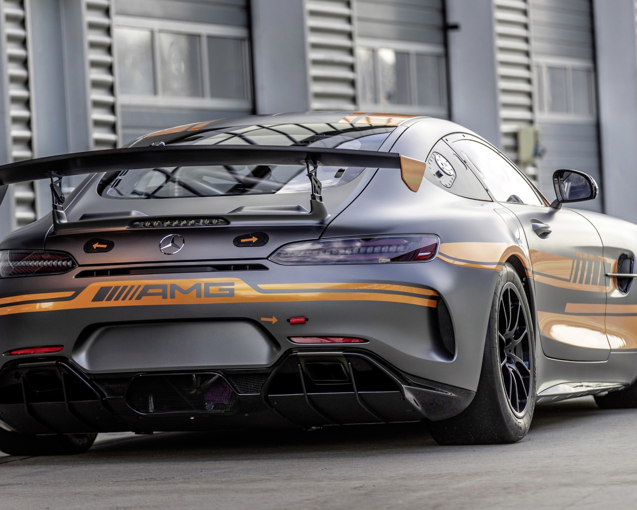 Серебристый автомобиль Mercedes-AMG GT4 2020 года вид сзади