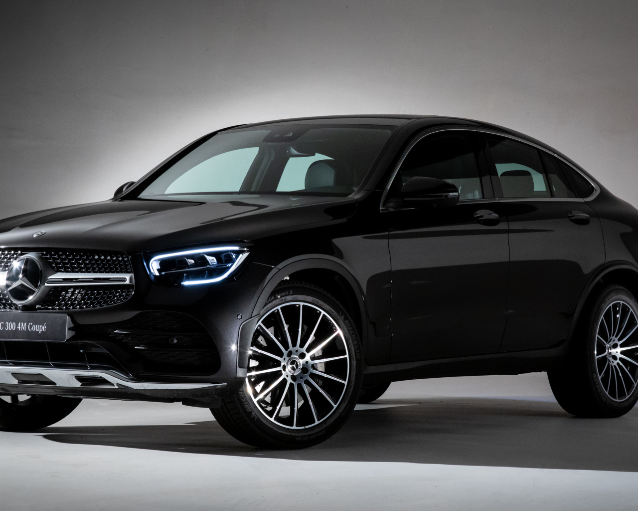 Черный стильный автомобиль Mercedes-Benz GLC 300,  2019 года на сером фоне