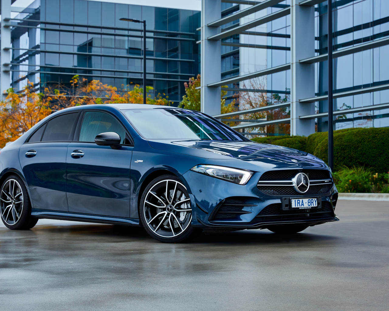 Синий автомобиль Mercedes-Benz AMG A 35, 2020 года на фоне здания 