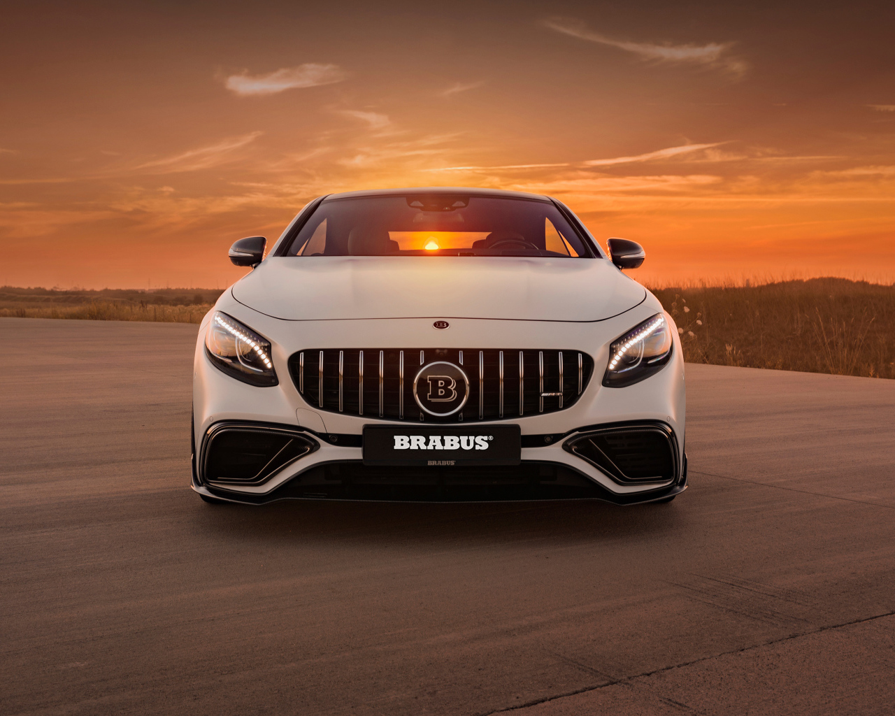 Белый автомобиль Mercedes Benz B63 S на фоне заката