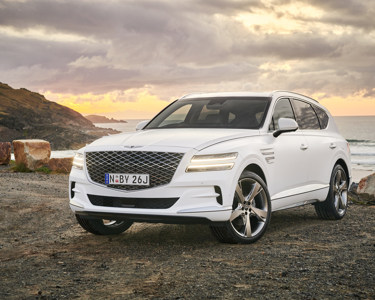 Белый автомобиль Genesis GV80 3.0D AWD 2020 года на фоне заката