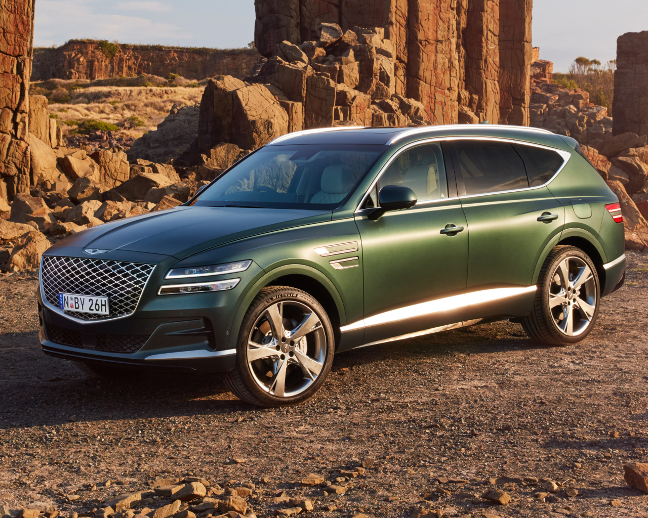 Зеленый автомобиль Genesis GV80 3.5T AWD 2020  года в горах