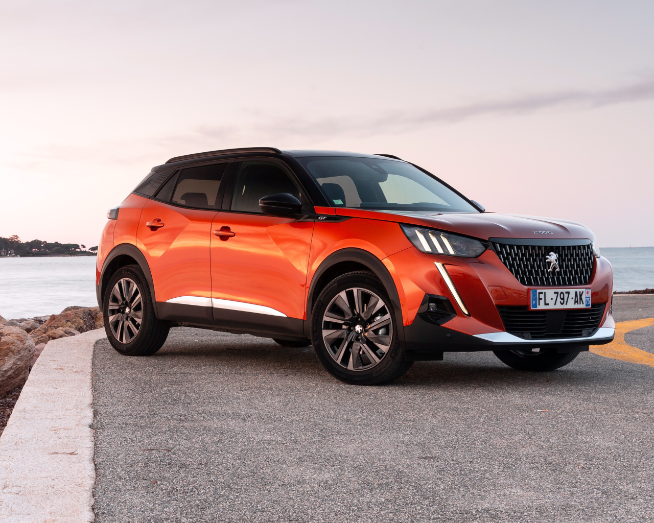 Красный внедорожник Peugeot 2008 GT 2019 года у океана