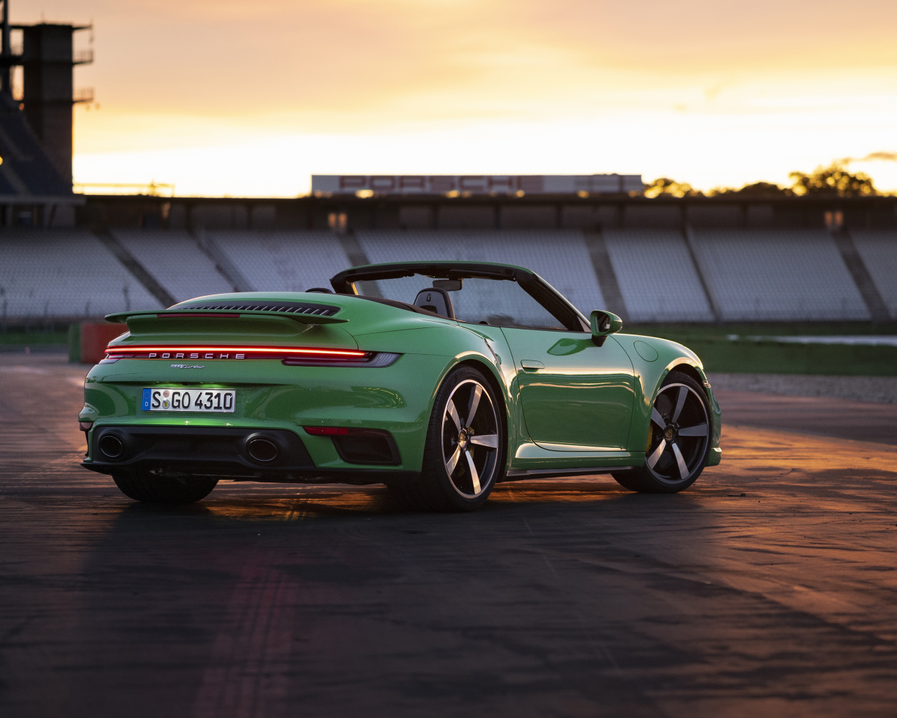 Зеленый автомобиль Porsche 911 Turbo Cabriolet 2020 года вид сзади