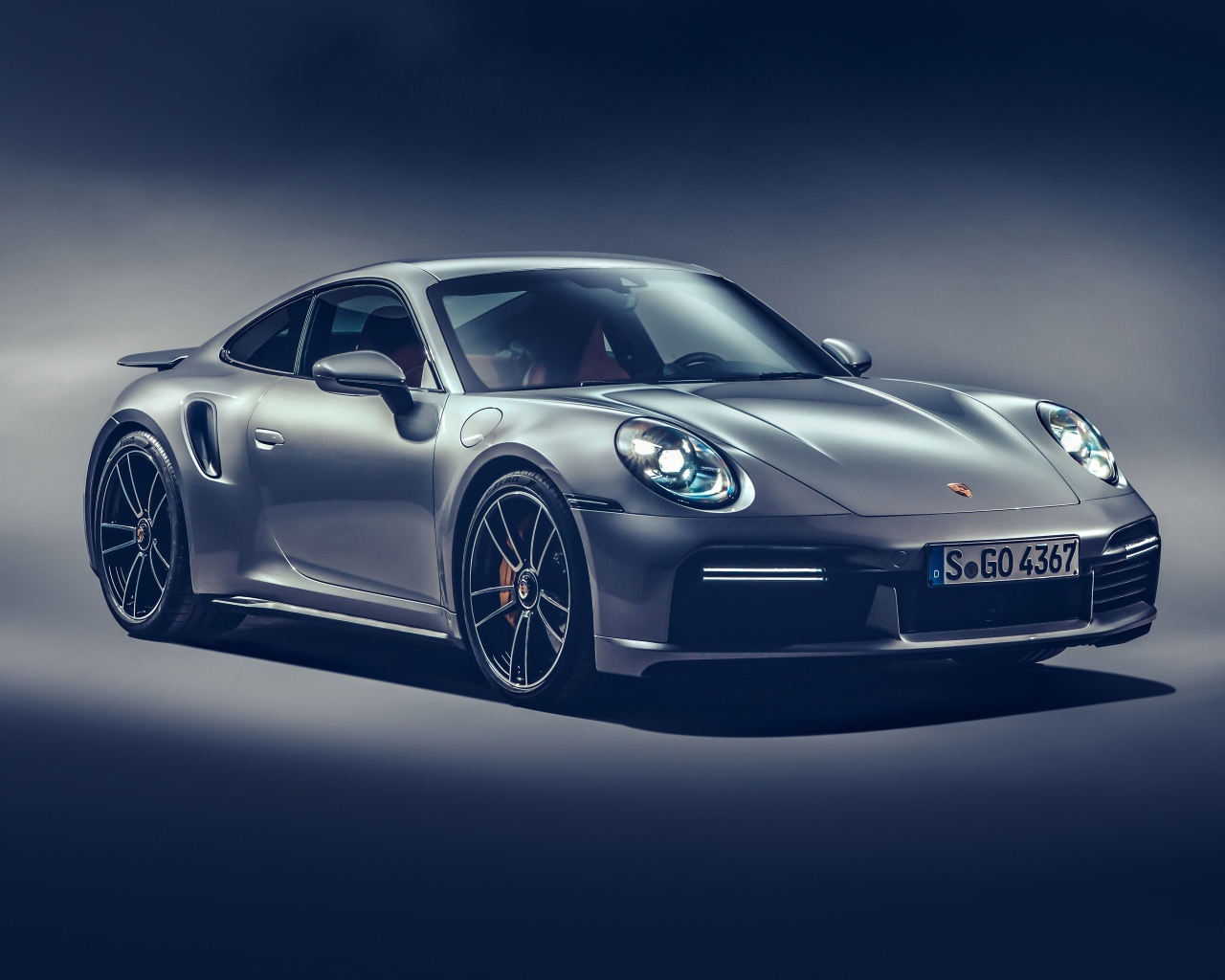 Автомобиль Porsche 911 Turbo S 2020 года на сером фоне