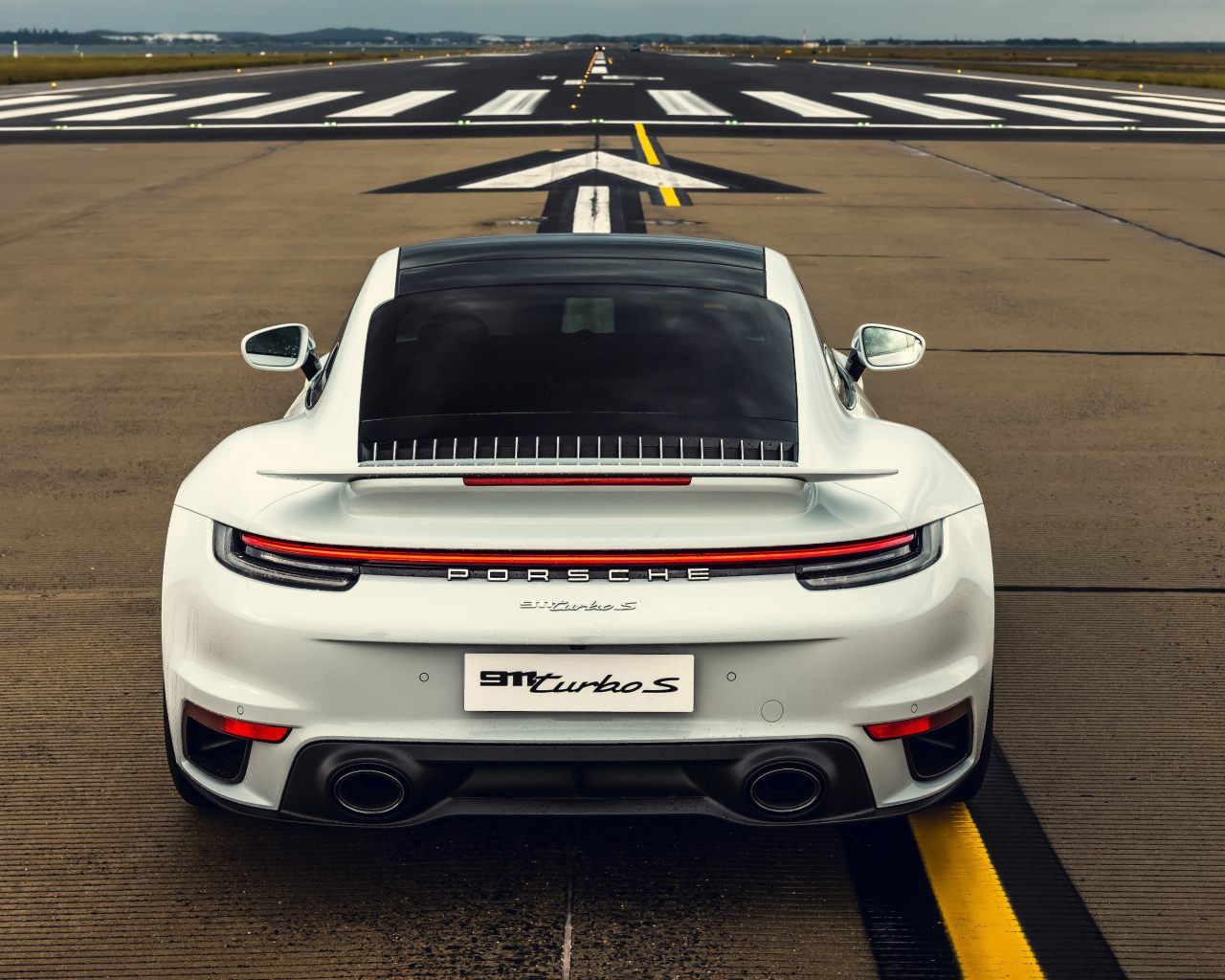 Белый автомобиль  Porsche 911 Turbo S 2020 года вид сзади
