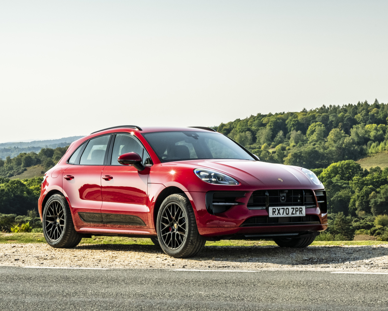 Красный автомобиль Porsche Macan GTS 2020  года в лучах солнца
