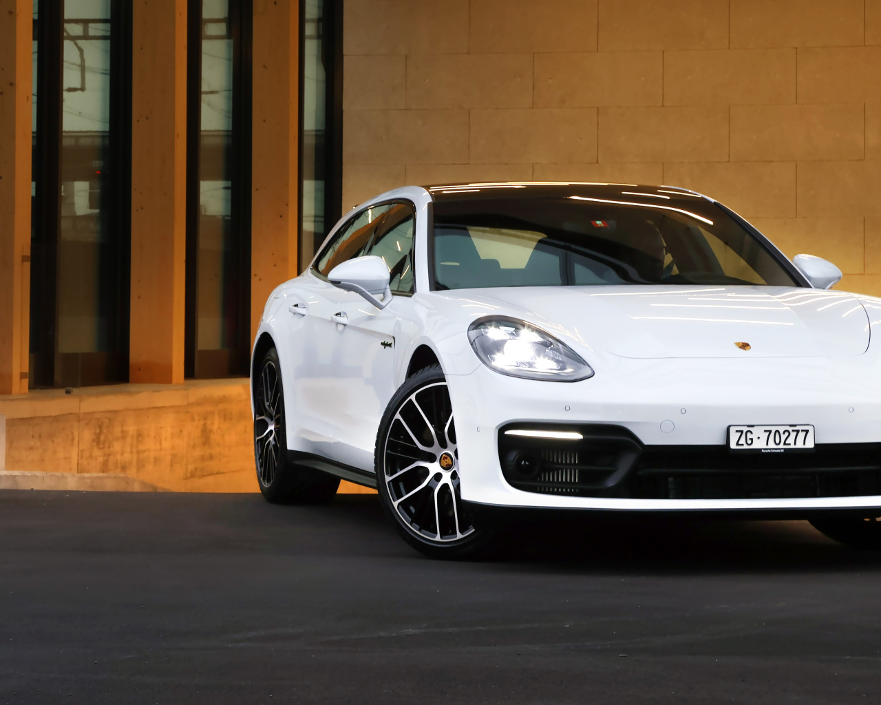 Белый автомобиль Porsche Panamera 4S E-Hybrid Sport Turismo 2020 года у дома