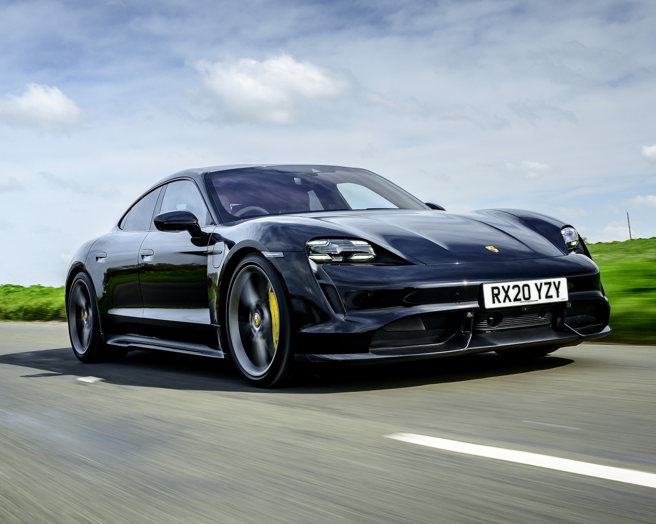 Черный автомобиль Porsche Taycan Turbo S 2020 года на скорости 