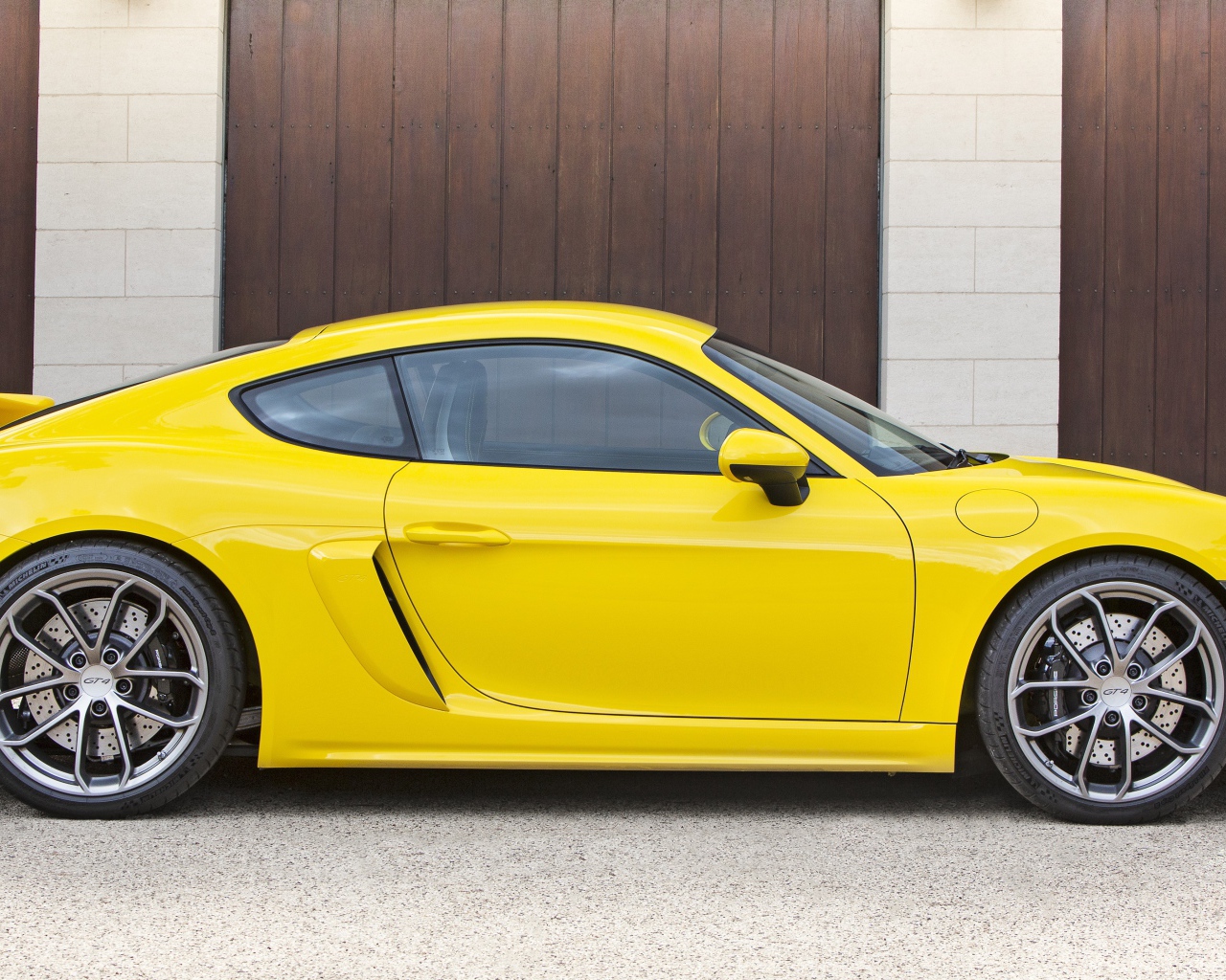 Желтый автомобиль Porsche 718 Cayman GT4 2020 года вид сбоку