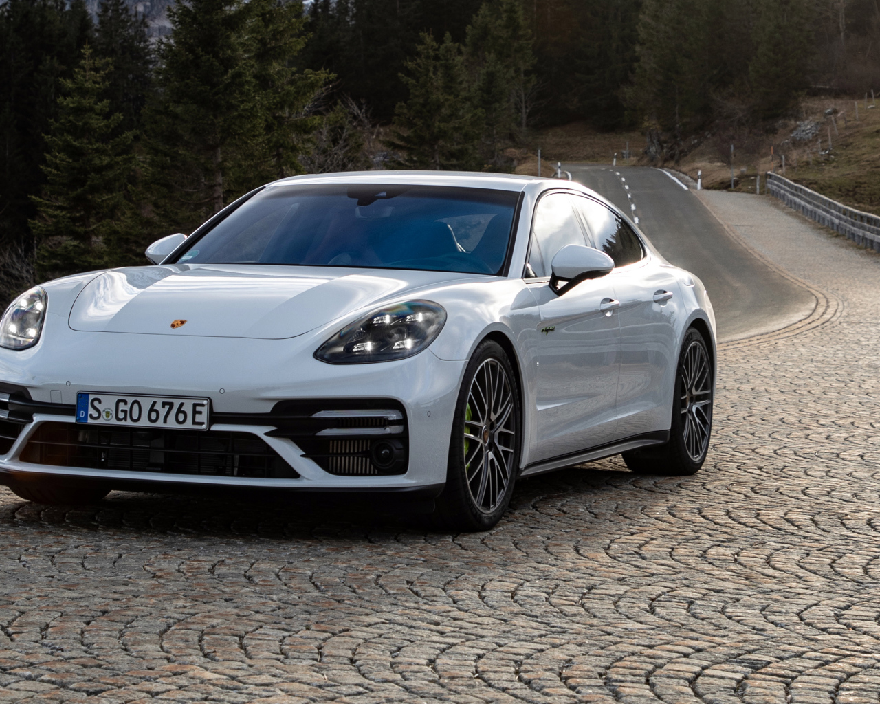 Белый автомобиль Porsche Panamera Turbo S E-Hybrid 2021 года на дороге